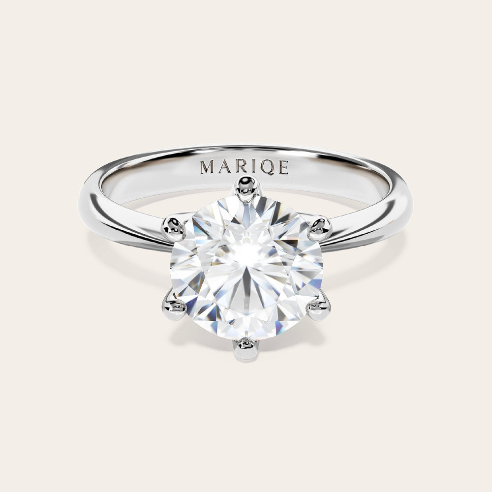 Eterna moissanite solitaire ring front view on tan background