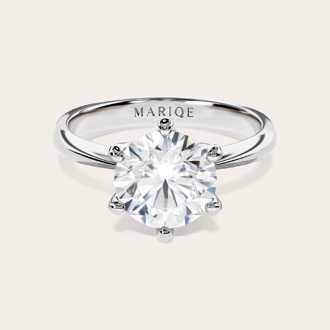 Eterna moissanite solitaire ring front view on tan background