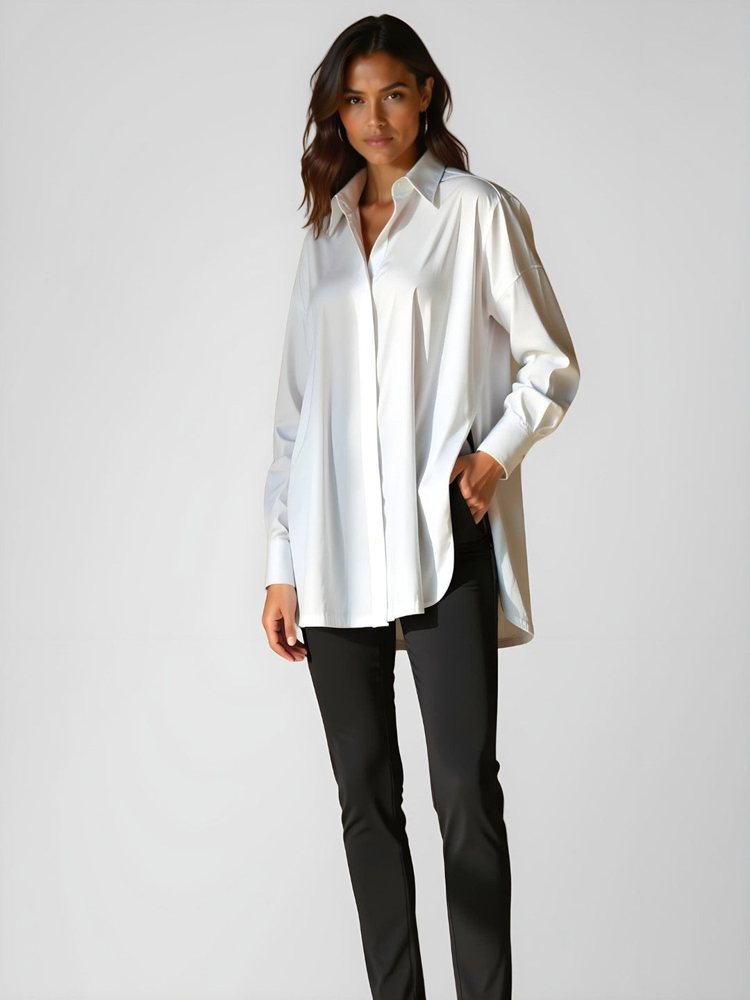 Woman wearing a white buttoned long shirt dress, standing and facing forward to show the fit and style.