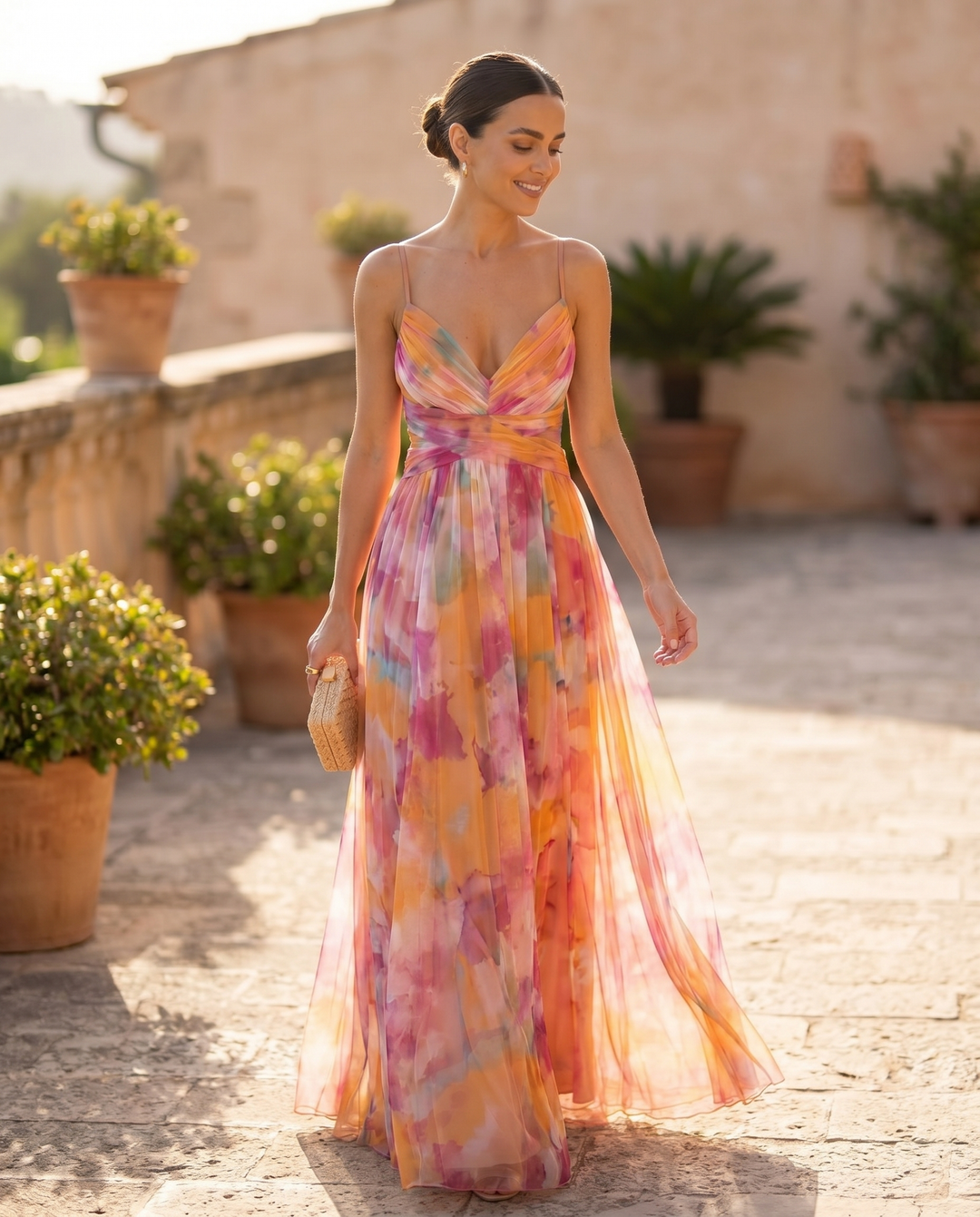 Woman wearing the Giselle floral maxi dress walking a sunlit terrace