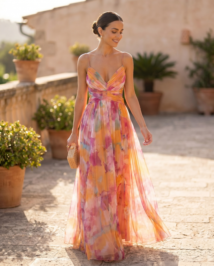 Woman wearing the Giselle floral maxi dress walking a sunlit terrace