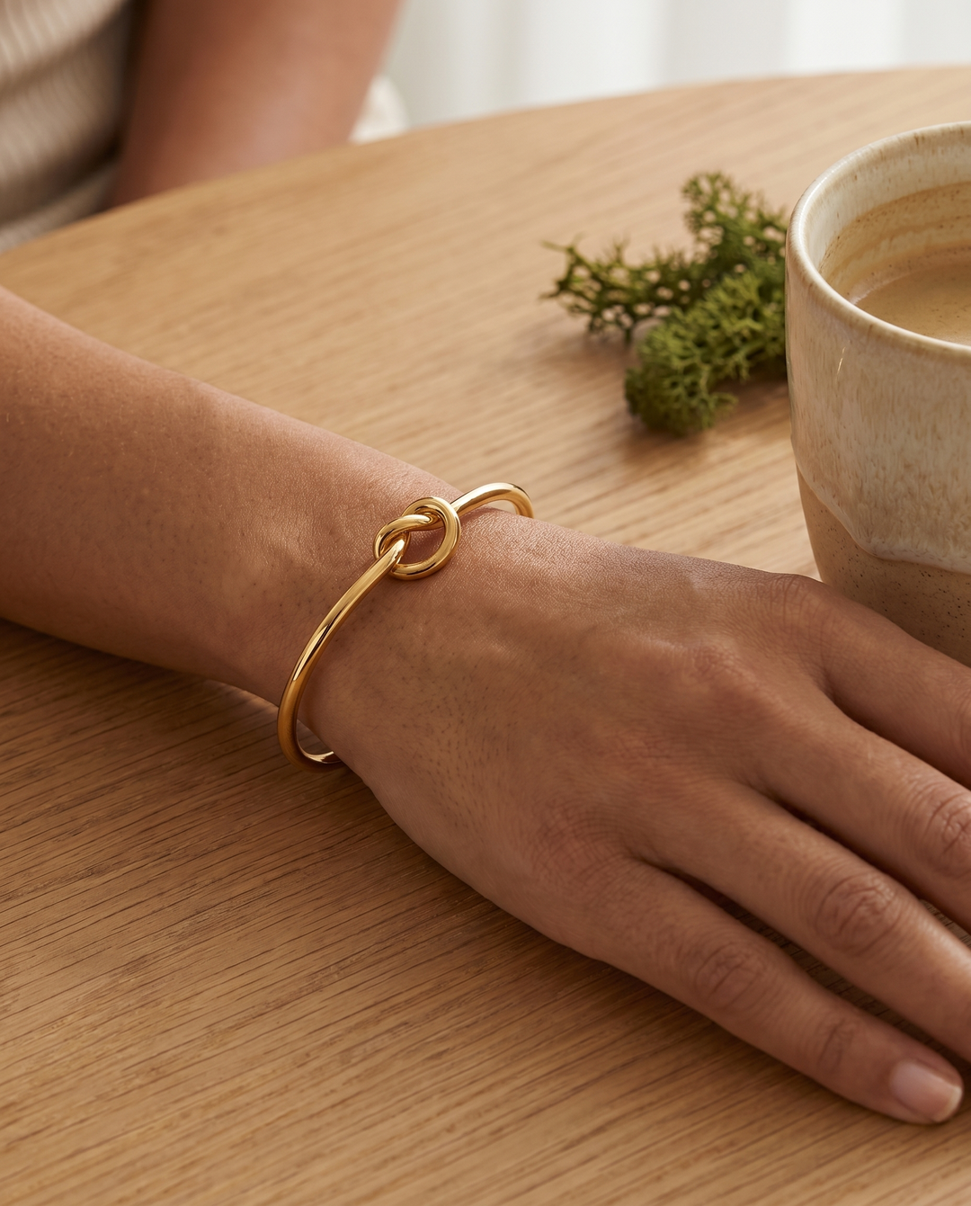 Gold knot cuff bracelet worn, second wrist angle