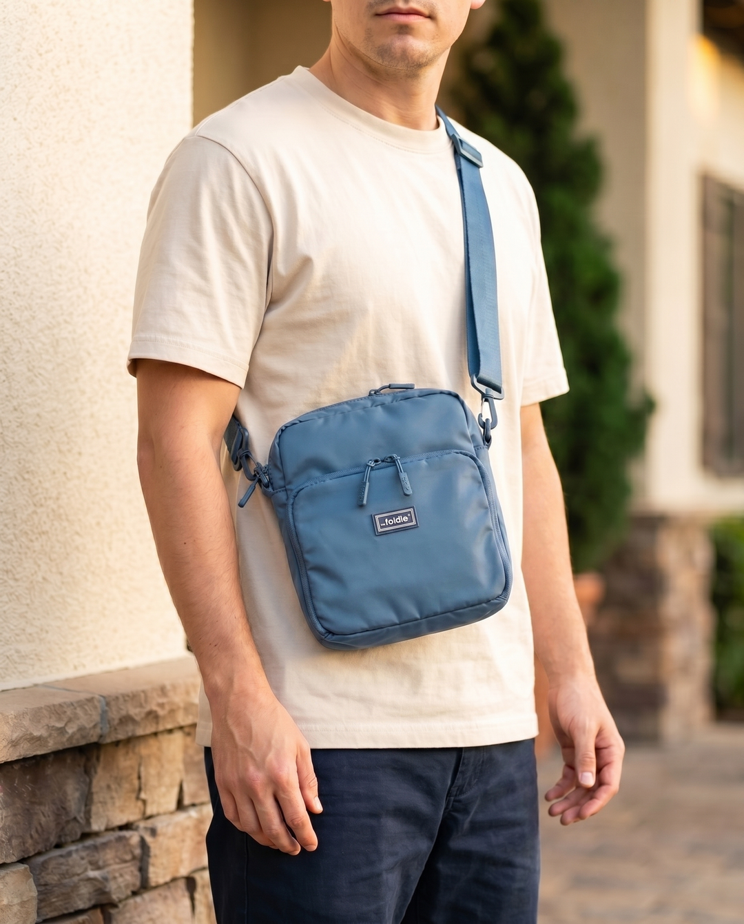 Foldable crossbody sling bag in Coastal Blue, worn
