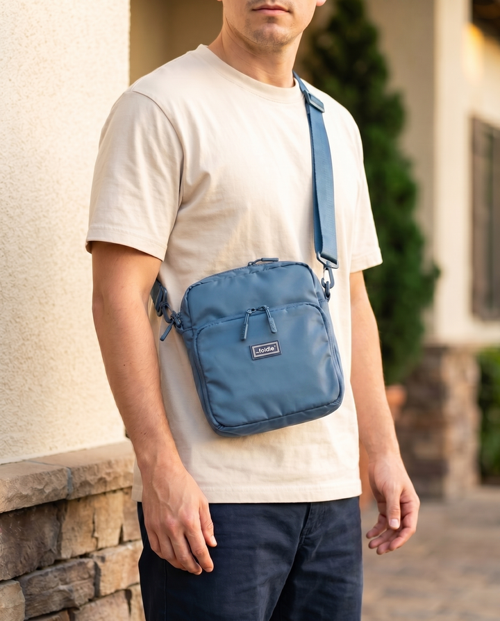 Foldable crossbody sling bag in Coastal Blue, worn