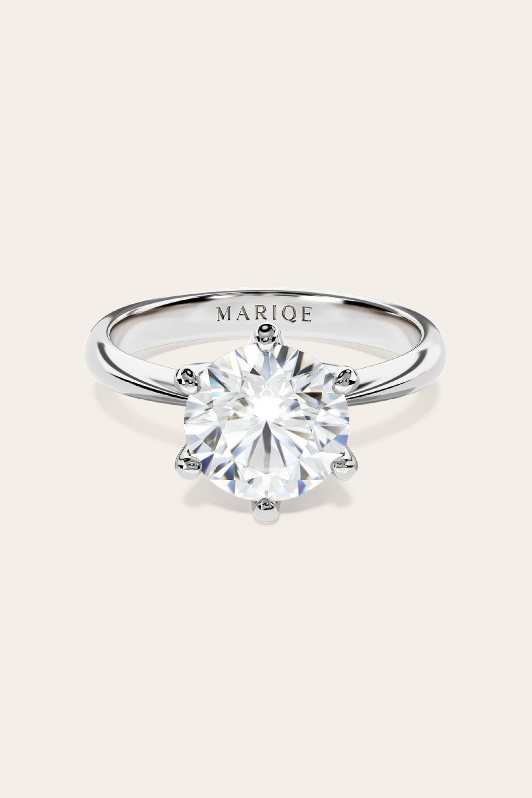 Eterna moissanite solitaire ring front view on tan background