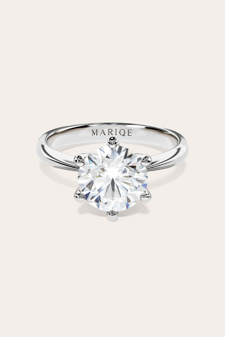 Eterna moissanite solitaire ring front view on tan background